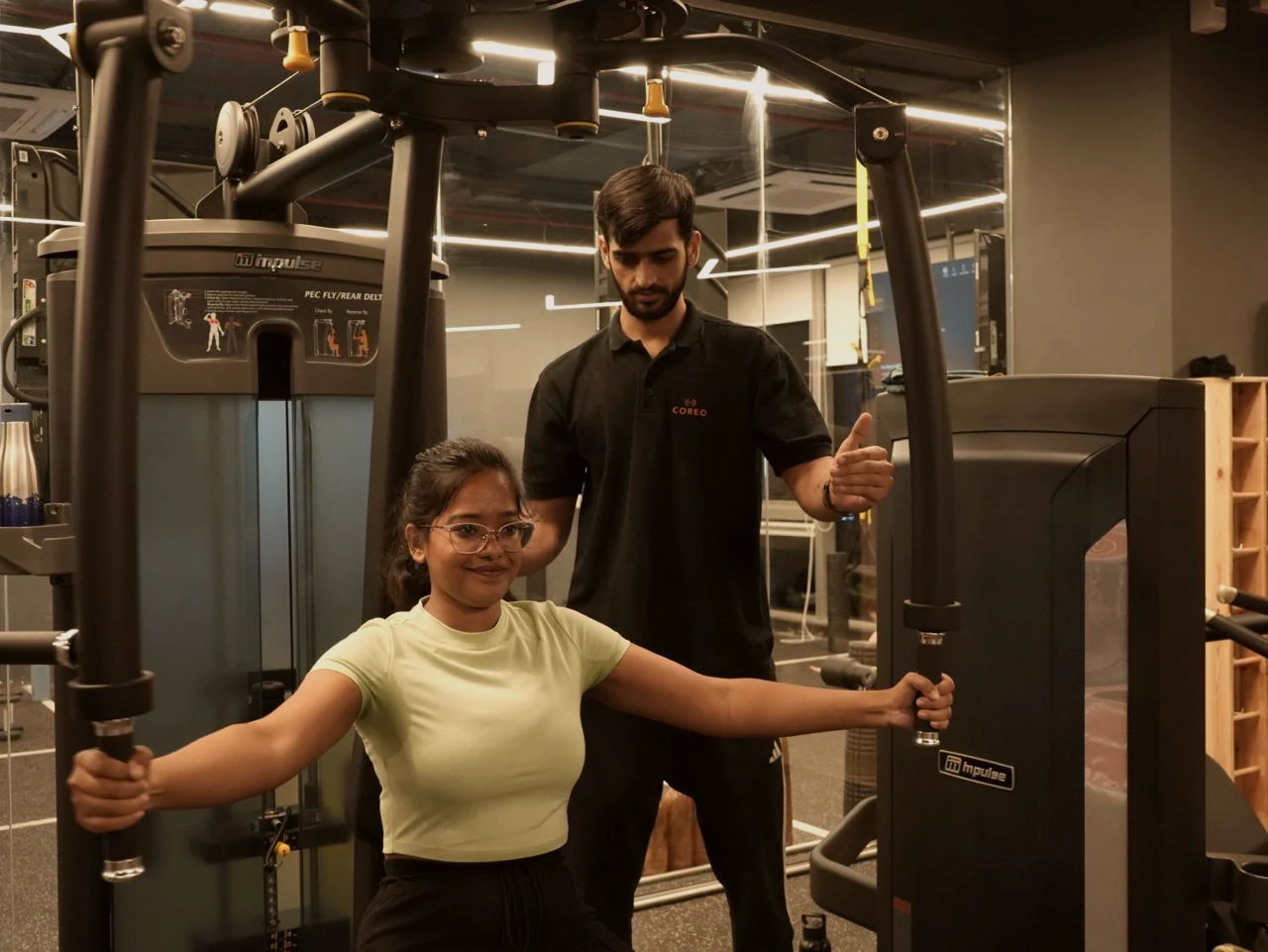 COREO coach supporting a member during a strength exercise