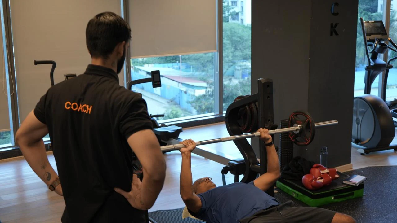 COREO coach guiding a member through strength training
