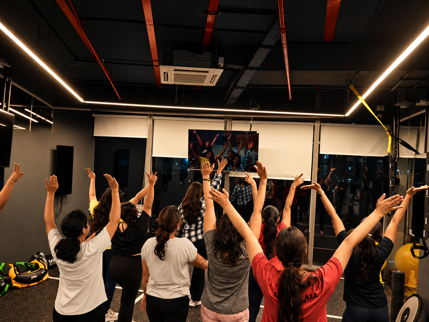 COREO group class raising their hands together